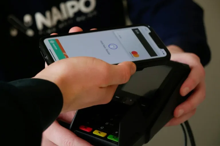 Technology 19 Person making a contactless payment using a smartphone over a card terminal.