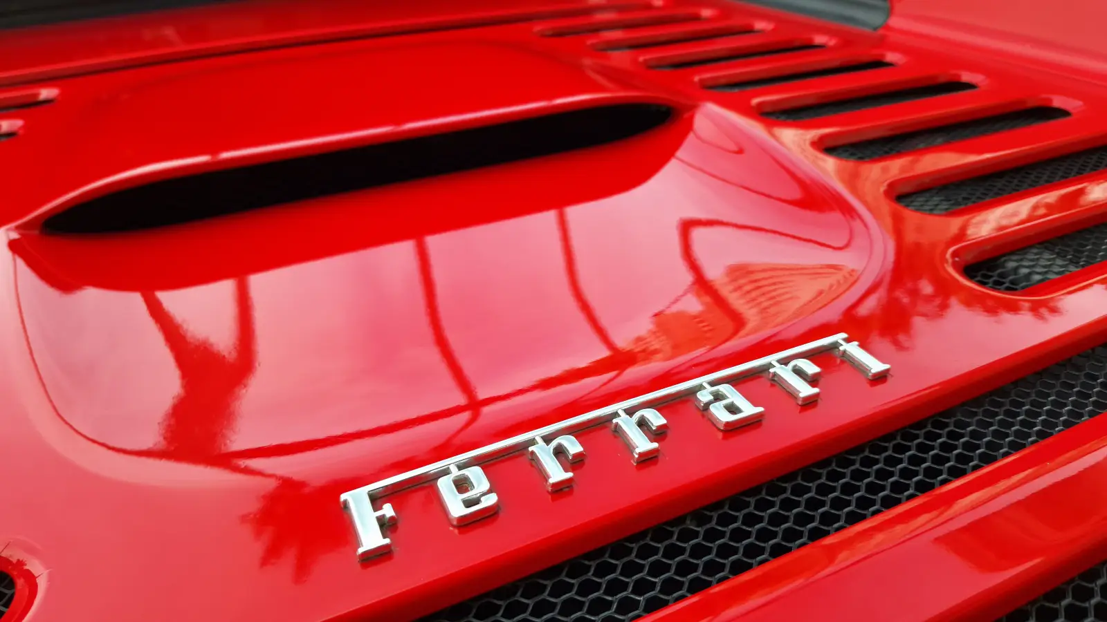 Ferrari’s 2030 Plan: More Models, Fewer Evs, And A €9 Billion Goal 6 Close-up of Ferrari F355 logo on red sports car hood, luxury Italian brand from Maranello