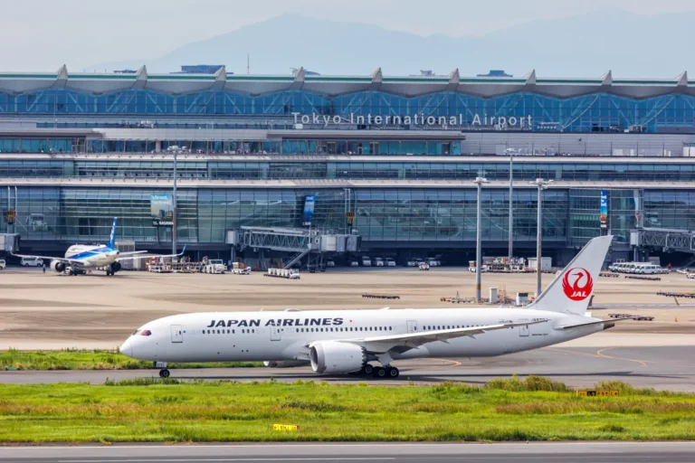 Aviation 29 Japan Airlines Boeing aircraft taxiing at Tokyo International Airport with terminal in the background