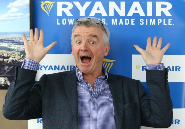 Ryanair CEO Michael O’Leary posing playfully in front of a Ryanair promotional backdrop.