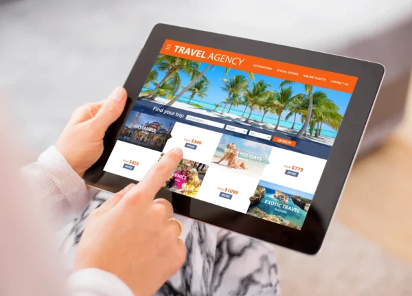 Person browsing online travel agency website on tablet, choosing holiday deals