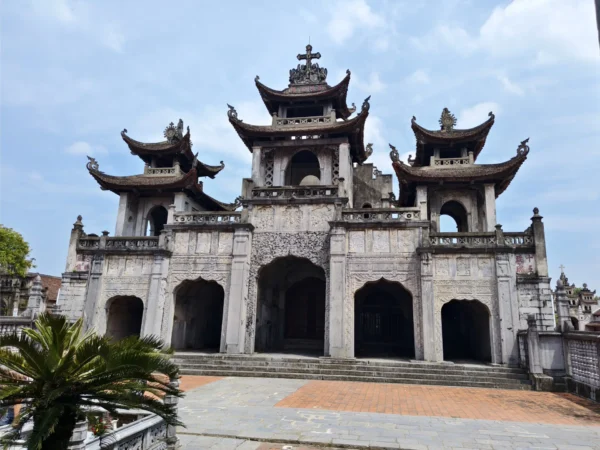 Home 22 Phat Diem Stone Cathedral in Ninh Binh, Vietnam, showcasing Eastern and Gothic architecture with ornate stone carvings and curved pagoda-style roofs