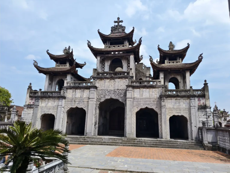 Phat Diem Stone Cathedral in Ninh Binh, Vietnam, showcasing Eastern and Gothic architecture with ornate stone carvings and curved pagoda-style roofs