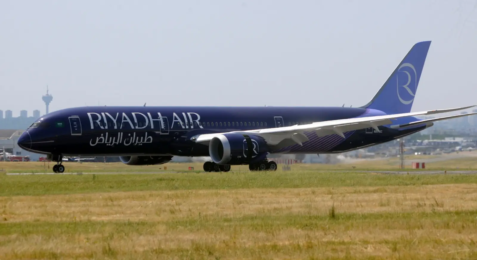 Riyadh Air Announces Inaugural London Flight On October 26 And Sfeer Loyalty Programme 3 Riyadh Air Boeing 787 Dreamliner in dark blue livery taxis on a runway with the airline’s logo visible on the tail.