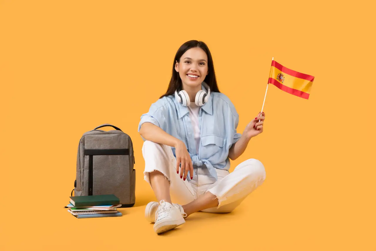 10 Spanish Immersion Techniques That Double Your Fluency During Travelling 1 Smiling student sitting with books and backpack while holding a Spanish flag on an orange background