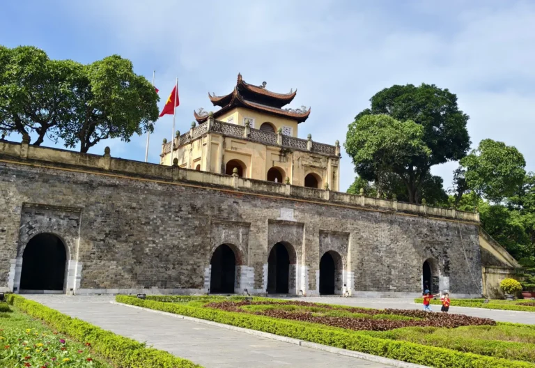 Main Gate of the Imperial Citadel of Thang Long in Hanoi, Vietnam, with flags and gardens.