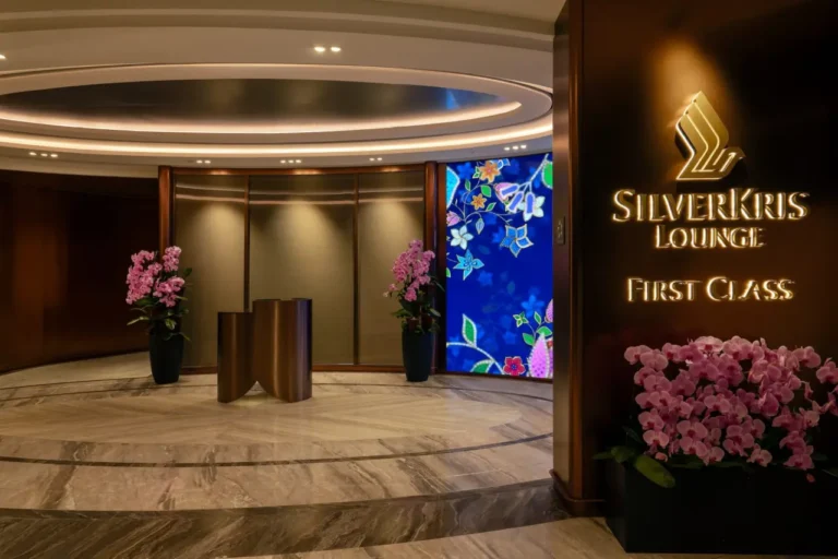Luxury Travel 18 Entrance to Singapore Airlines’ First Class SilverKris Lounge at Changi Airport, featuring warm lighting, marble floors, and floral decor.