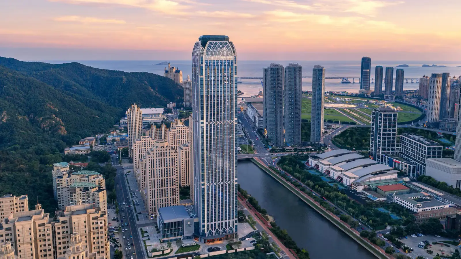 Pan Pacific Dalian tower overlooking the city skyline, coastline and surrounding mountains.