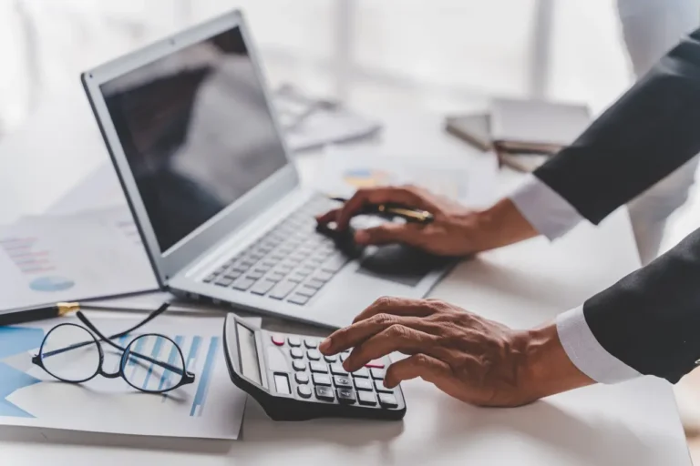 Other News 20 Business professional using calculator and laptop for financial analysis