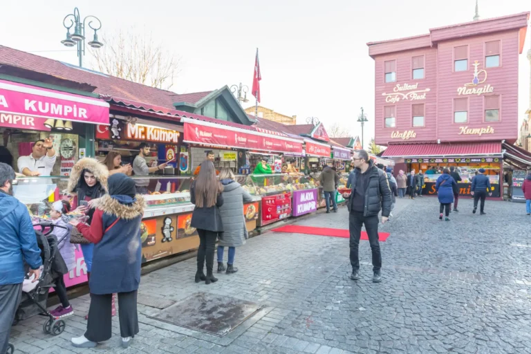 People buying food from street vendors at an outdoor market area in Istanbul.