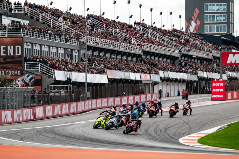 MotoGP riders race through the opening laps at Circuit Ricardo Tormo with packed grandstands behind them during the Valencia Grand Prix.