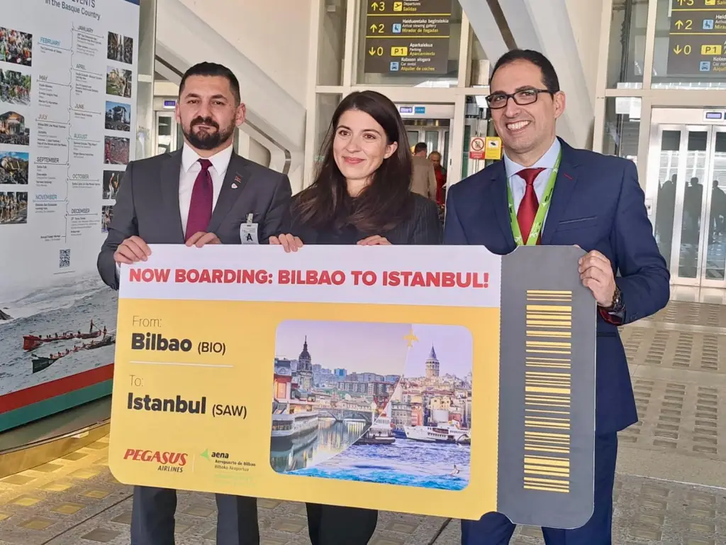 Pegasus Airlines Launches Direct Istanbul–Bilbao Flights 3 Airport staff display an oversized boarding pass announcing the new Bilbao to Istanbul Pegasus Airlines service.