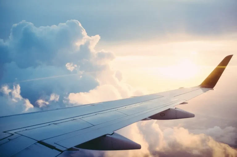 Technology 12 Airplane wing flying above clouds during a commercial flight at sunset