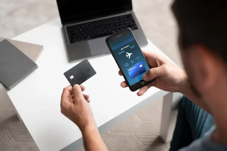 Technology 16 Man holding a credit card while viewing a digital airline ticket on a smartphone.