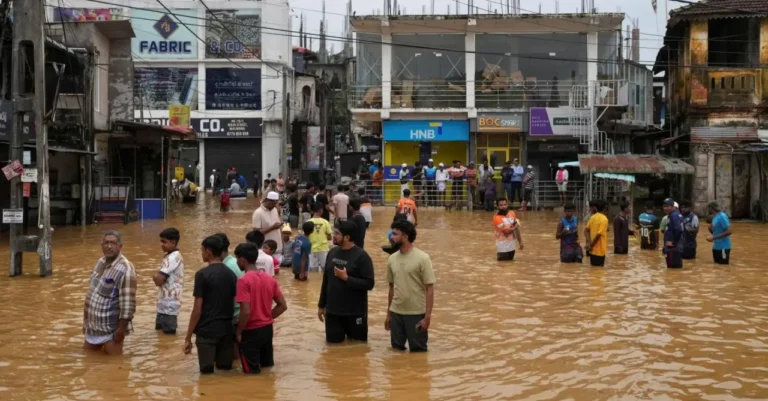 Other News 17 People standing in waist-deep floodwater on a commercial street as buildings and shops remain partially submerged.