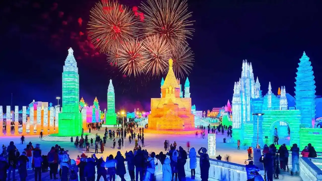 Fireworks above illuminated ice sculptures at Harbin Ice and Snow World at night.