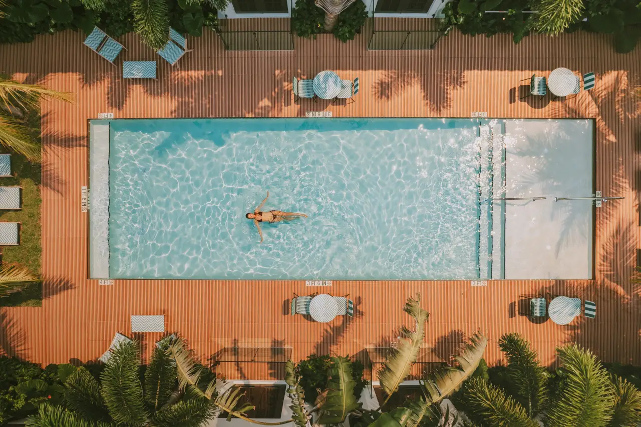 Aerial view of a guest swimming in a courtyard pool at Maison Felix in Miami Beach