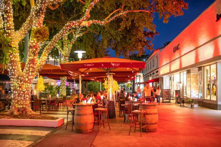 People dining outdoors at a steakhouse on Lincoln Road at night in South Beach, Miami.