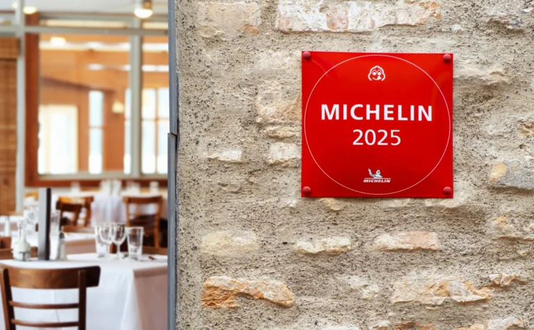 Michelin 2025 plaque mounted on a stone wall outside a restaurant.
