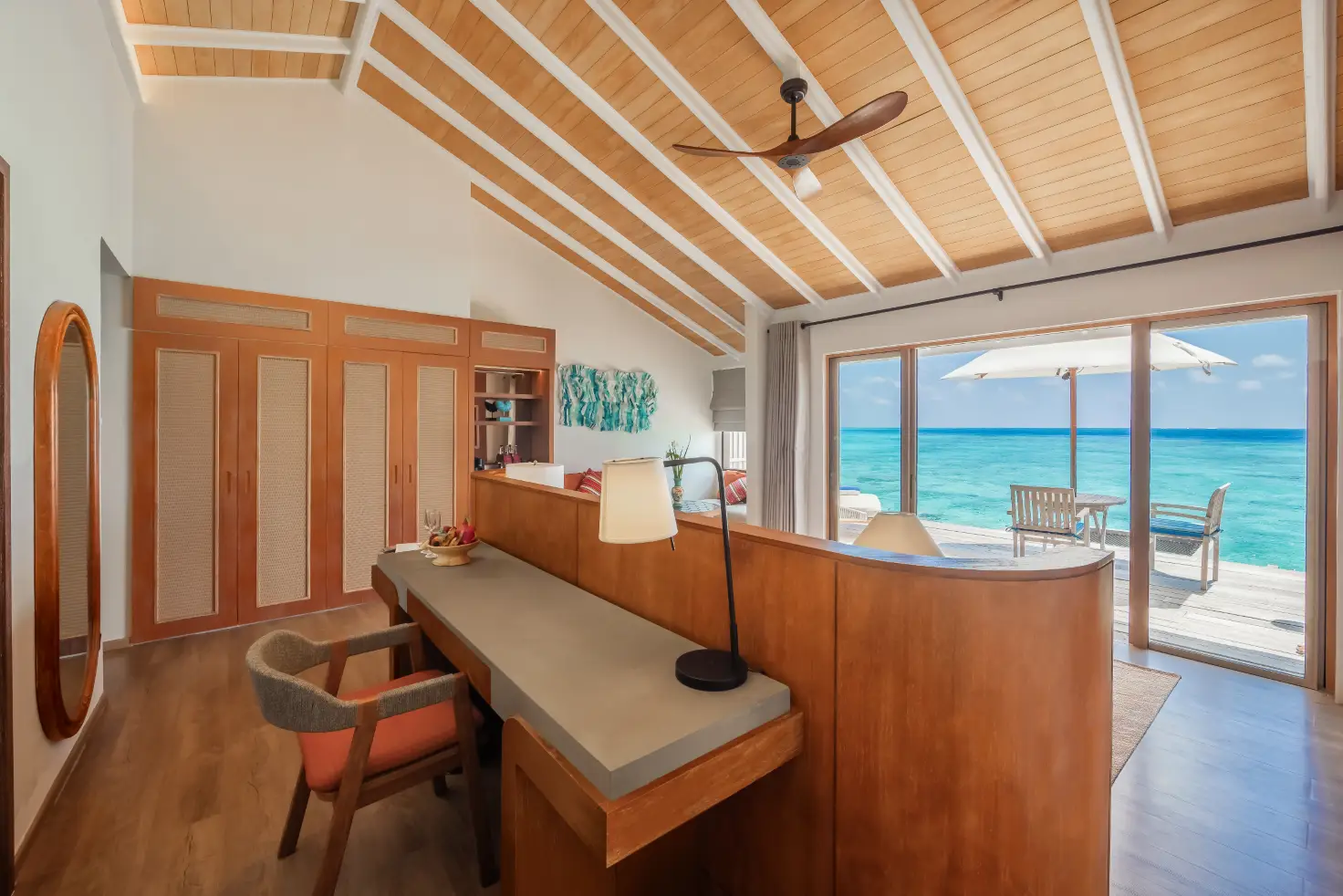 Nh Collection Maldives Reethi Resort Debuts After Major Renovations 4 Interior of an overwater villa at NH Collection Maldives Reethi Resort with ocean-view deck and private seating area.