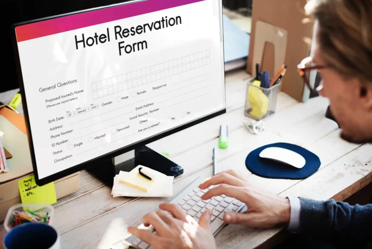 Technology 18 Person typing on a computer with a hotel reservation form displayed on the monitor.