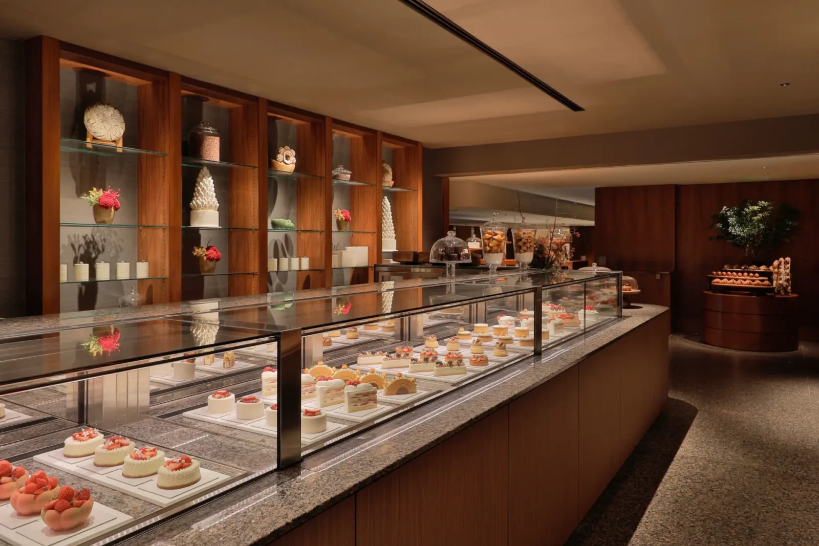 Pastry Boutique counter at Park Hyatt Tokyo displaying cakes and desserts in a glass showcase with warm wood interiors.
