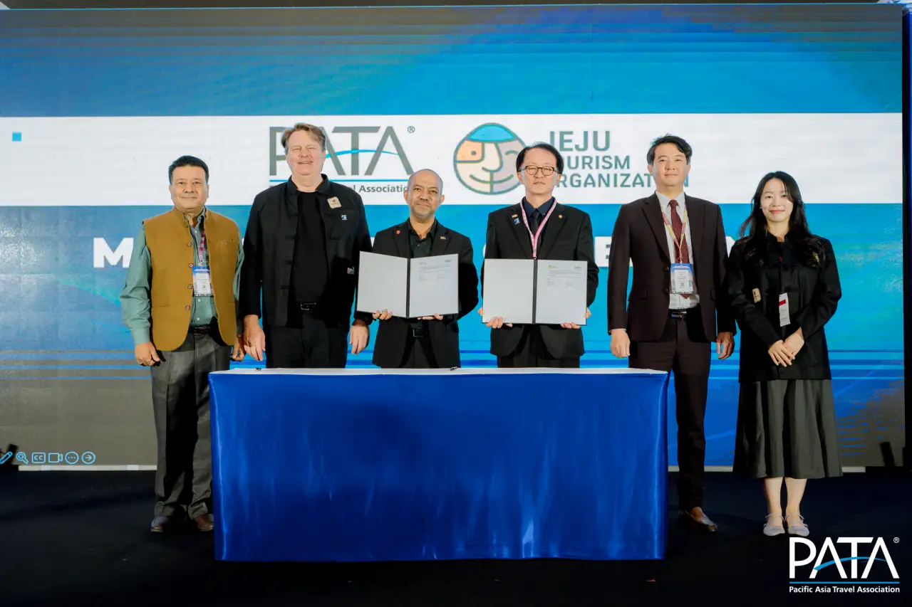 PATA and Jeju Tourism Organization leaders pose on stage after signing an MoU at the PATA Destination Marketing Forum 2025.