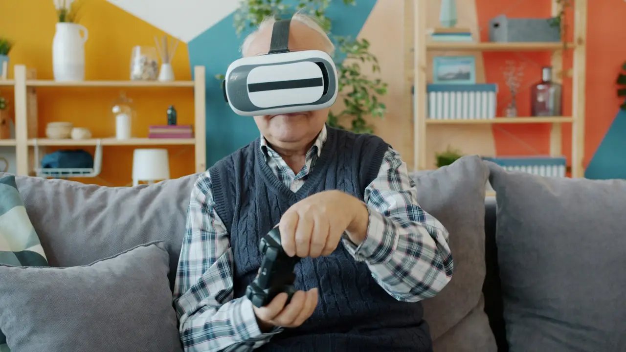 Older man wearing a VR headset and holding a controller while seated on a sofa
