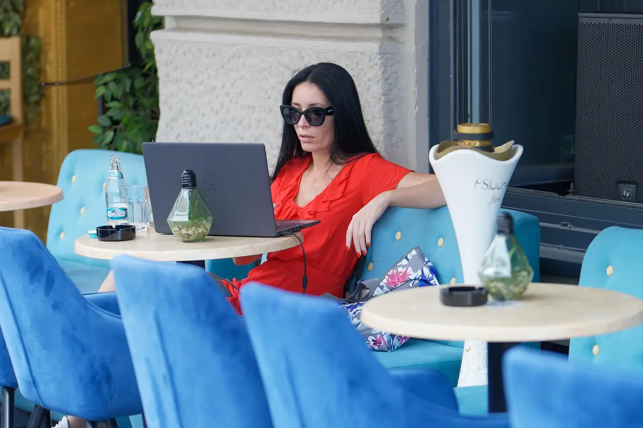 Woman using public WiFi on a laptop at an outdoor café.