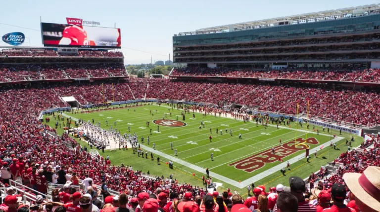 Packed Levi’s Stadium during an NFL football game, with a full crowd surrounding the field on a sunny day.