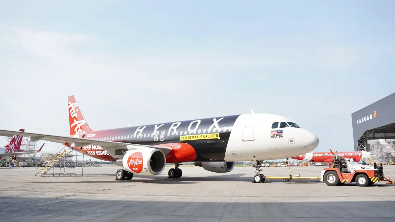 Airasia And Hyrox Partner To Bring Fitness Communities Together Across Asia Pacific Through Purposeful Travel 8 AirAsia aircraft with HYROX co-branded livery parked on airport tarmac near hangar, showcasing “Keep Moving, Keep Rising” partnership branding.