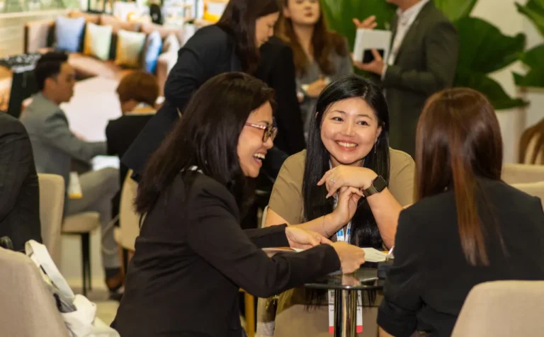 Business professionals networking and discussing at a conference lounge during a meetings event.