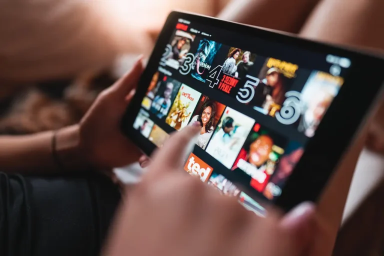Technology 22 Person using a tablet to browse streaming movies and shows for digital entertainment at home.
