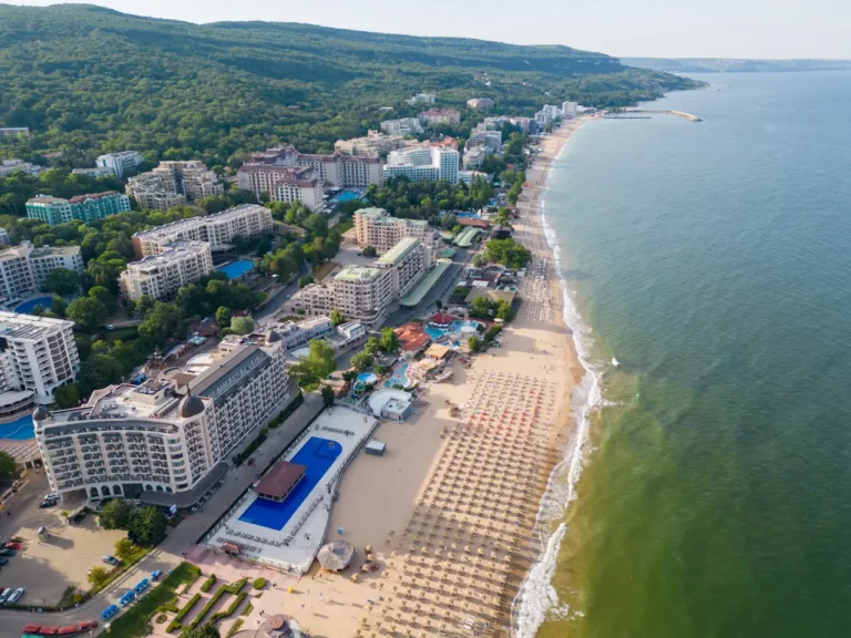 Aerial view of Golden Sands beach with seaside hotels, umbrellas, and green hills near Varna, Bulgaria.