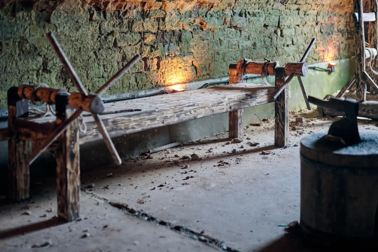 Why Medieval Torture Museum Is So Instagrammable 2 Wooden medieval torture rack with ropes and metal cranks inside a dimly lit stone dungeon.