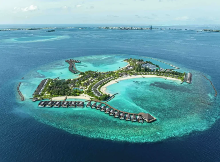 Aerial view of one of the new Maldives resorts at dusitD2 Feydhoo Maldives with curved overwater villas, white-sand beaches, and a turquoise lagoon.