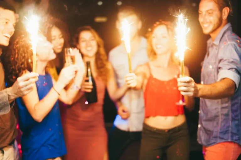 Other News 5 Group of young adults holding sparklers and champagne while celebrating at a crowded nightclub