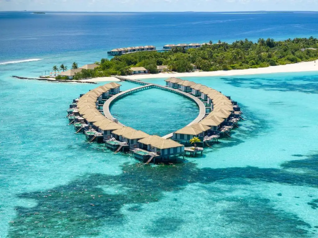 New Maldives Hotels &Amp; Resorts, 2025 &Amp; 2026 4 Aerial view of circular overwater villas surrounding a turquoise lagoon at Noku Maldives resort.