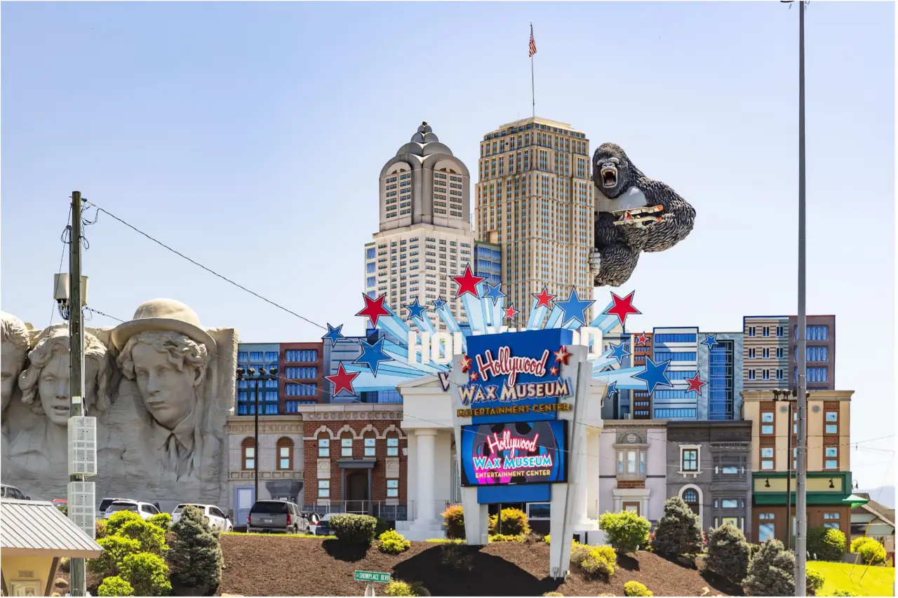 Exterior view of the Hollywood Wax Museum Entertainment Center in Pigeon Forge, Tennessee, with colorful signage, themed building facades, and a giant King Kong figure.