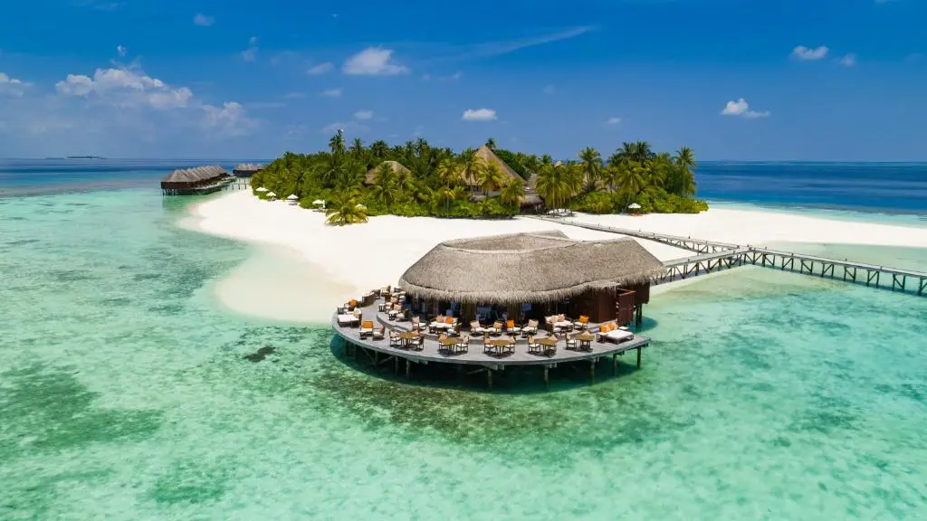 New Maldives Hotels &Amp; Resorts, 2025 &Amp; 2026 5 Overwater restaurant pavilion connected by a jetty to a palm-lined island at V Villas Maldives at Mirihi, surrounded by a turquoise lagoon.