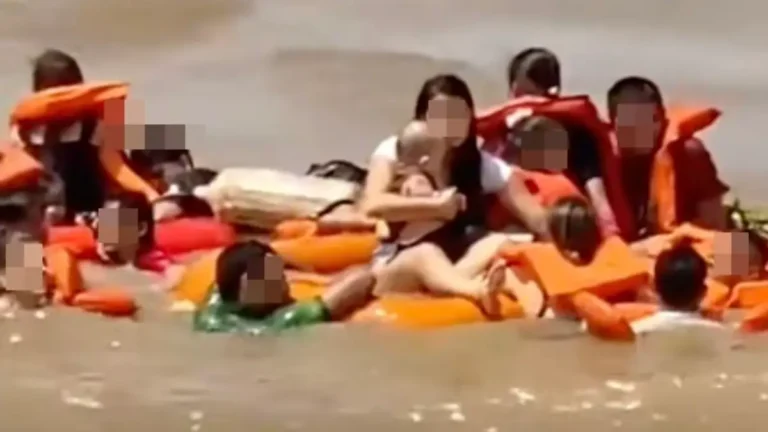 Survivors wearing life jackets cling to flotation devices after tourist boat sinks in the Amazon River near Manaus