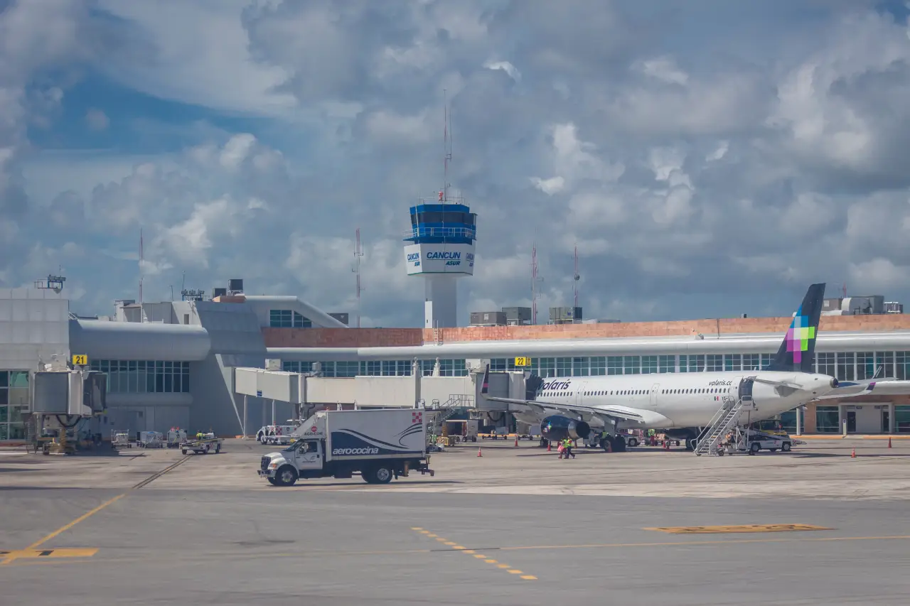 Cancun International Airport terminal and control tower with aircraft on the tarmac in Mexico
