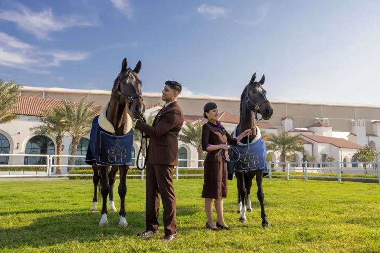 Etihad Airways cabin crew pose with thoroughbred horses at Abu Dhabi Gold Cup venue
