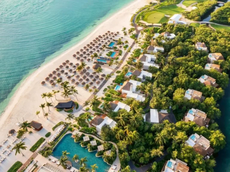 Aerial view of Fairmont Mayakoba resort with beachfront villas, pools, and tropical forest in Playa del Carmen, Mexico.