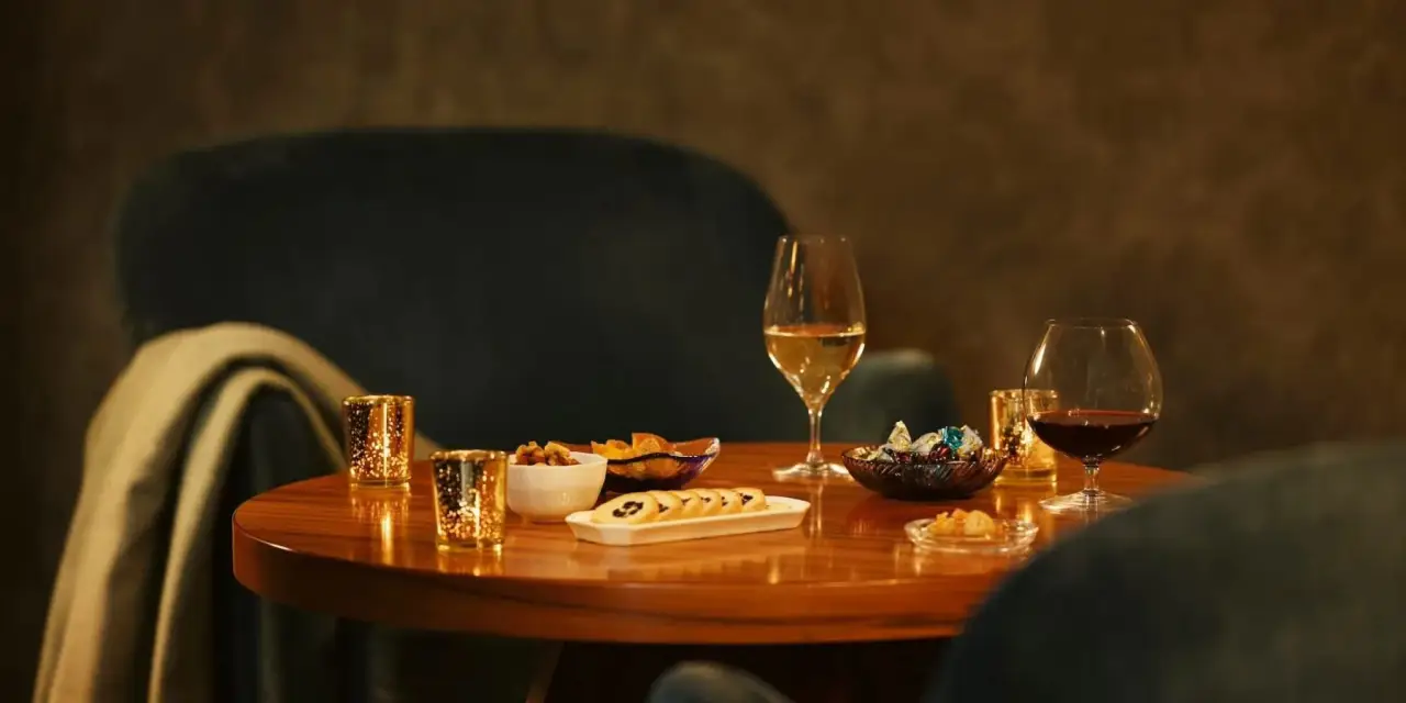 Japan’s First Luxury Hotel Housed In A Former Prison Will Open In June 6 Elegant lounge setting at HOSHINOYA Nara Prison with wine glasses and small plates on a wooden table