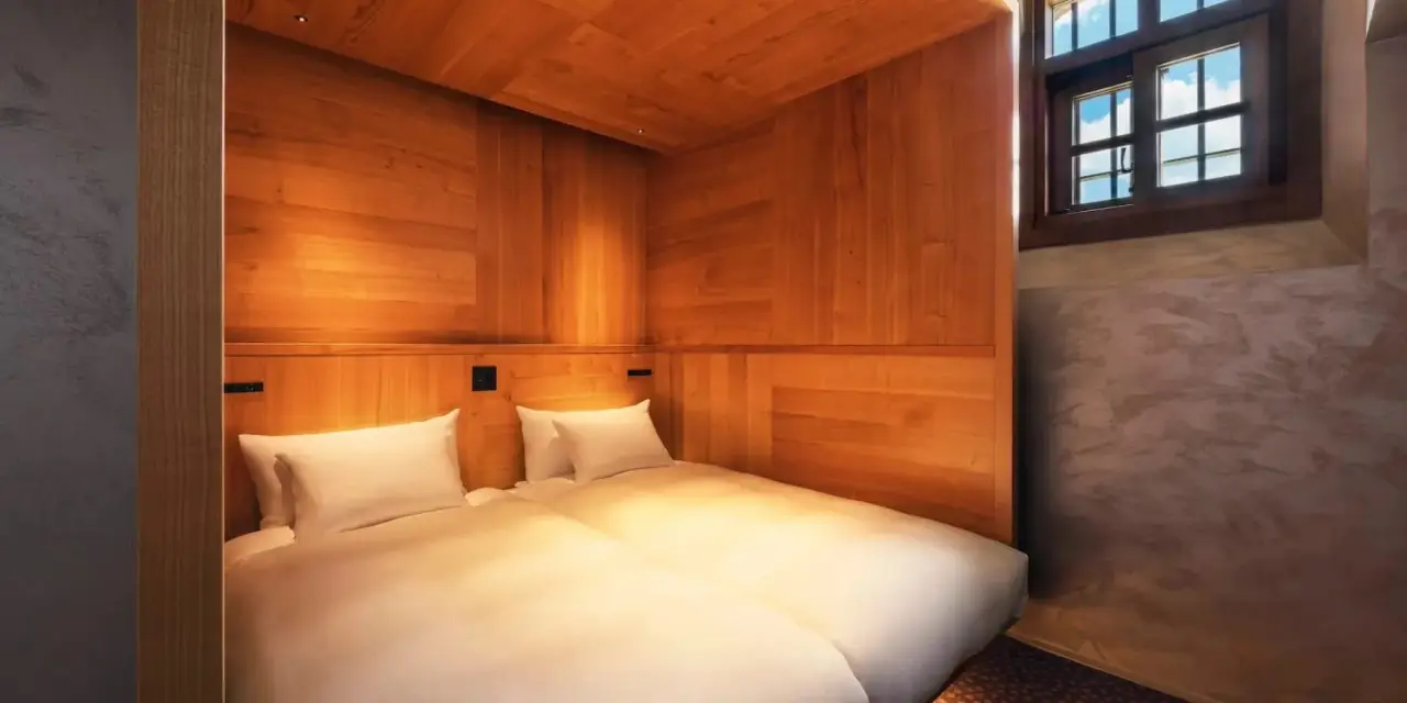Japan’s First Luxury Hotel Housed In A Former Prison Will Open In June 4 Twin bedroom suite at HOSHINOYA Nara Prison featuring warm wood interiors and preserved historic architectural elements