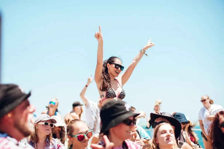 Luxury Travel 39 Festival guests dancing outdoors at a beachside music event under clear blue skies