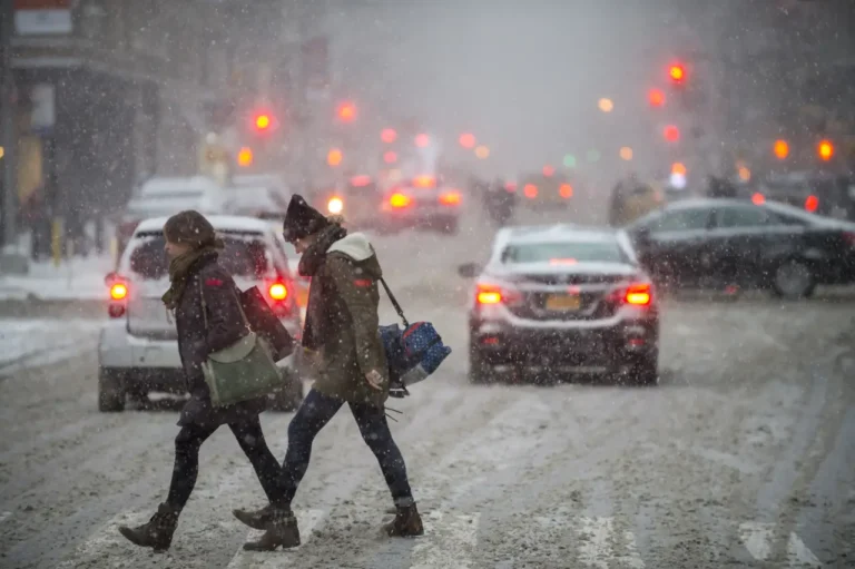 Other News 22 Pedestrians cross a snow-covered Fifth Avenue as traffic slows during a winter storm near Manhattan’s Flatiron Building.