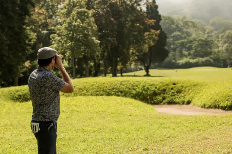 Sports Tourism 23 Golfer standing on a lush tropical course, looking across the fairway toward tree-lined greens under warm sunlight.