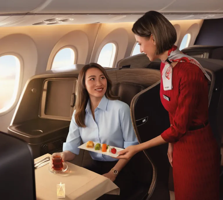 Zheng Qinwen smiling as a Turkish Airlines' flight attendant serves dessert in a luxury business class airplane cabin